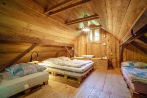 a bedroom with two beds in a log cabin at Gozdna koča Studeno in Kočevje