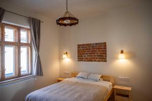 une chambre avec un lit et un mur de briques dans l'établissement Curte la Munte - charming village house, à Sebeşu de Sus