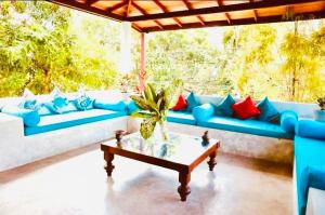a living room with blue couches and a coffee table at Coastal Cloud Surf - Walk To Dewata Beach in Unawatuna