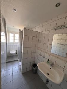 une salle de bain blanche avec un lavabo et des toilettes dans l'établissement Gasthaus & Pension Grüner Baum Eberbach, à Eberbach 12 autres photos