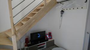 Cette chambre dispose d'un escalier et d'une télévision à écran plat. dans l'établissement Le Pigeonnier De La Villa Lamoure, à Villaudric