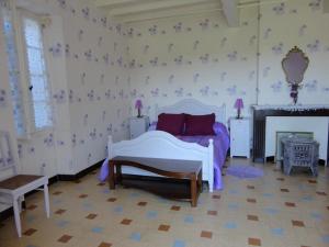 - une chambre avec un lit et des oreillers violets dans l'établissement Gîte de Castellasses, à Castelmayran