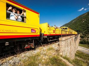 un train jaune avec des gens qui regardent par les fenêtres dans l'établissement Chalet Mitoyen au Cœur des Pistes - FR-1-593-98, aux Angles 3 autres photos