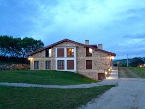 a brick house with lights on the side of it at Apartamentos Villa Sofía in San Vicente de la Barquera