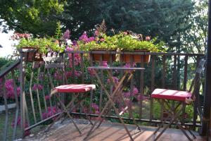 a balcony with two chairs and flowers on a fence at Freistehendes Haus Mit Garten Zur Alleinigen Nutzung in Umbertide