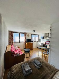 a bedroom with a bed and a desk and a kitchen at Le refuge du Cerf in Allemont