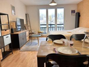 a room with a bed and a table with plates on it at Studio coin montagne au pied des pistes - 4 couchages - Risoul 1850 - FR-1-330-88 in Risoul