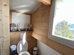 La salle de bains est pourvue de toilettes et d'un mur en bois. dans l'établissement Chalet spacieux aux Angles avec 4 chambres et coin détente - FR-1-593-84, aux Angles 10 autres photos