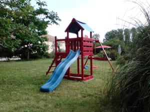 une aire de jeux avec un toboggan dans une cour dans l'établissement Gîte Braunis 4 étoiles, à Bourran