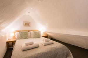 une chambre avec un lit avec deux oreillers dessus dans l'établissement The Dairy Cotswolds Cottage Farm With Pool, à Lechlade 122 autres photos