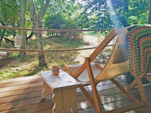 a rocking chair and a table on a deck at The Apple Bobber - Ukc7130 in Cratfield