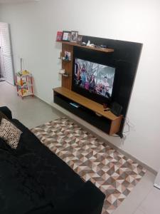 a living room with a flat screen tv at Bem praiana in Praia Grande