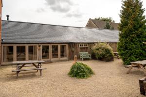 - une table de pique-nique devant un bâtiment dans l'établissement The Dairy Cotswolds Cottage Farm With Pool, à Lechlade