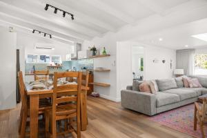 a kitchen and living room with a table and a couch at Bawley Point Beach House - renovated beach escape in Bawley Point
