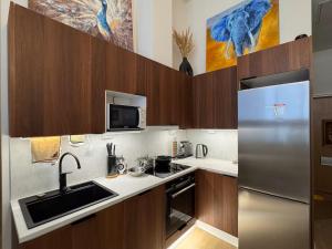 a kitchen with a sink and a refrigerator at Double Sofa Bed in a Stunningly Tall Shared Studio in Helsinki
