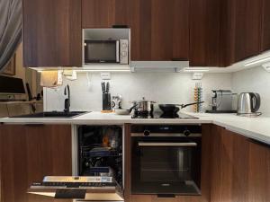 a kitchen with a stove and a microwave at Double Sofa Bed in a Stunningly Tall Shared Studio in Helsinki +5 photos