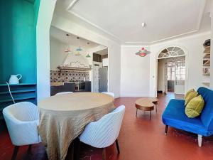 un salon avec une table et un canapé bleu dans l'établissement Loft au coeur de Marseille - Spacieux & Unique, à La Celle-sous-Gouzon