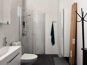 a bathroom with a shower and a toilet and a sink at Double Sofa Bed in a Stunningly Tall Shared Studio in Helsinki