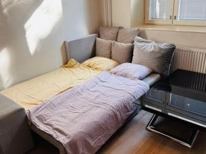 a bed in the corner of a room at Double Sofa Bed in a Stunningly Tall Shared Studio in Helsinki
