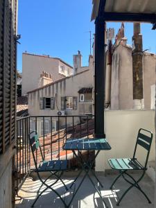 deux chaises et une table sur un balcon dans l'établissement Loft au coeur de Marseille - Spacieux & Unique, à La Celle-sous-Gouzon