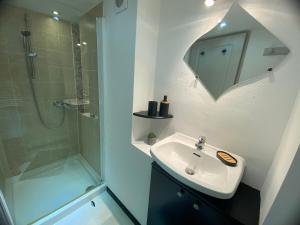 een witte badkamer met een wastafel en een douche bij La Petite Maison in Moyrazès