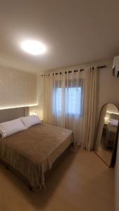 Giường trong phòng chung tại Churrasqueira, Ar, Piscina, Frigobar e muito mais