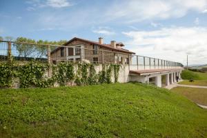 an old house on a grassy hill at Apartamentos Villa Sofía in San Vicente de la Barquera