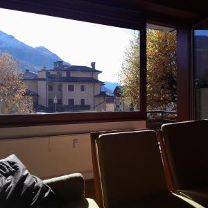 Bormio 5 villa في بورميو: نافذة كبيرة بها كرسيان وإطلالة على مبنى