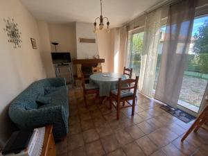 a living room with a table and chairs and a couch at Les Buis in Dieupentale