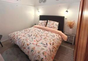a bedroom with a bed with a floral bedspread at Le jardin privatif de Pauze Cauterets wifi et parking gratuits Vue panoramique in Cauterets