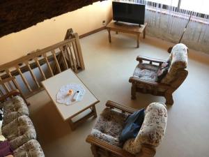 un salon avec des canapés, une table et une télévision dans l'établissement Gîte près de l'auberge, à Saint-Antoine