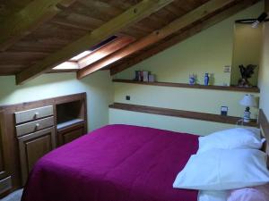 - une chambre avec un lit et une couverture violette dans l'établissement Gîte près de l'auberge, à Saint-Antoine