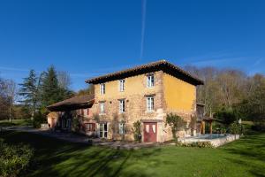 a large brick house in a field of grass at Le moulin de Varax in Saint-Paul-de-Varax