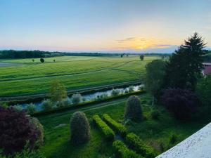 a sunset over a field with a river and trees at Elegante bilocale a due passi dal centro in Saluggia