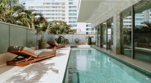 basen z 2 leżakami obok budynku w obiekcie Penthouse con piscina y jacuzzi privado w mieście Estación El Salto