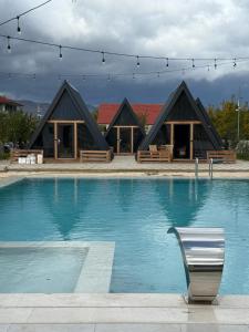 een gebouw met een zwembad met een stoel ervoor bij United Villas in Pogradec