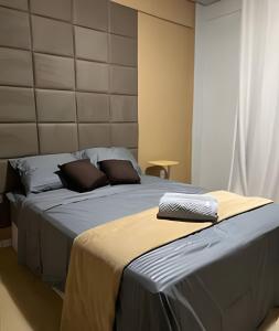 un lit avec deux oreillers dessus dans une chambre dans l'établissement Loft confortavel Prox Arena Pantanal, à Cuiabá