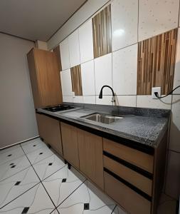 une cuisine avec un évier et un plan de travail dans l'établissement Loft confortavel Prox Arena Pantanal, à Cuiabá