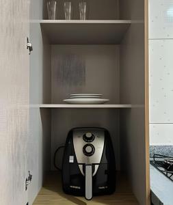 une imprimante noir et blanc posée dans un meuble dans l'établissement Loft confortavel Prox Arena Pantanal, à Cuiabá