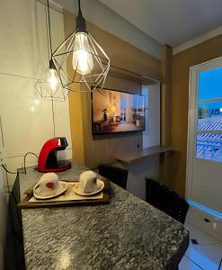 une cuisine avec une table avec deux chapeaux dans l'établissement Loft confortavel Prox Arena Pantanal, à Cuiabá