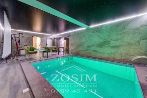 a swimming pool in a house with a rock wall at Bazin interior 3 dormitoare Cricova in Cricova
