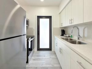 a kitchen with white cabinets and a large doorway at Lux Miami Escape - Near Brickell- Free Parking in Miami