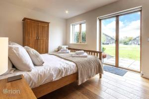 a bedroom with a large bed and a large window at Waters Edge 16, Heron Lodge in South Cerney +25 photos