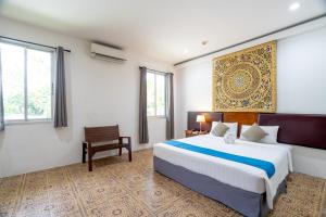 une chambre avec un grand lit et une chaise dans l'établissement Blue Beach Apartment, à Rawai Beach 122 autres photos