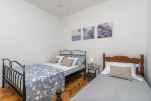 1 Schlafzimmer mit 2 Einzelbetten und 1 Bett sidx sidx sidx in der Unterkunft Modernes Ferienhaus mit Terrasse und Meerblick, nur wenige Schritte vom Strand in einem schönen Fischerdorf in Vinišće + 26 Fotos