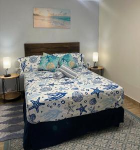 una camera da letto con un letto con un piumone blu e bianco di 4B Holiday Haven a Buccoo