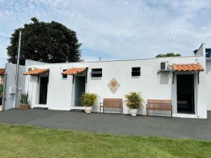 Pousada Vale Canastra في ساو جواو باتيستا دو غلوريا: مبنى أبيض على كرسيين أمامه