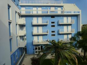 滨海库普拉Wohnung In Strandnähe的一座蓝色的建筑,前面有棕榈树