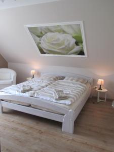 a bedroom with a bed with a painting on the wall at Große Wohnung In Diekmannshausen in Süderschweiburg