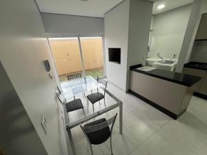 a bathroom with a glass table with chairs and a sink at Apartamento com jardim e ar condicionado na sala e quartos na Av Blumenau in Sorriso